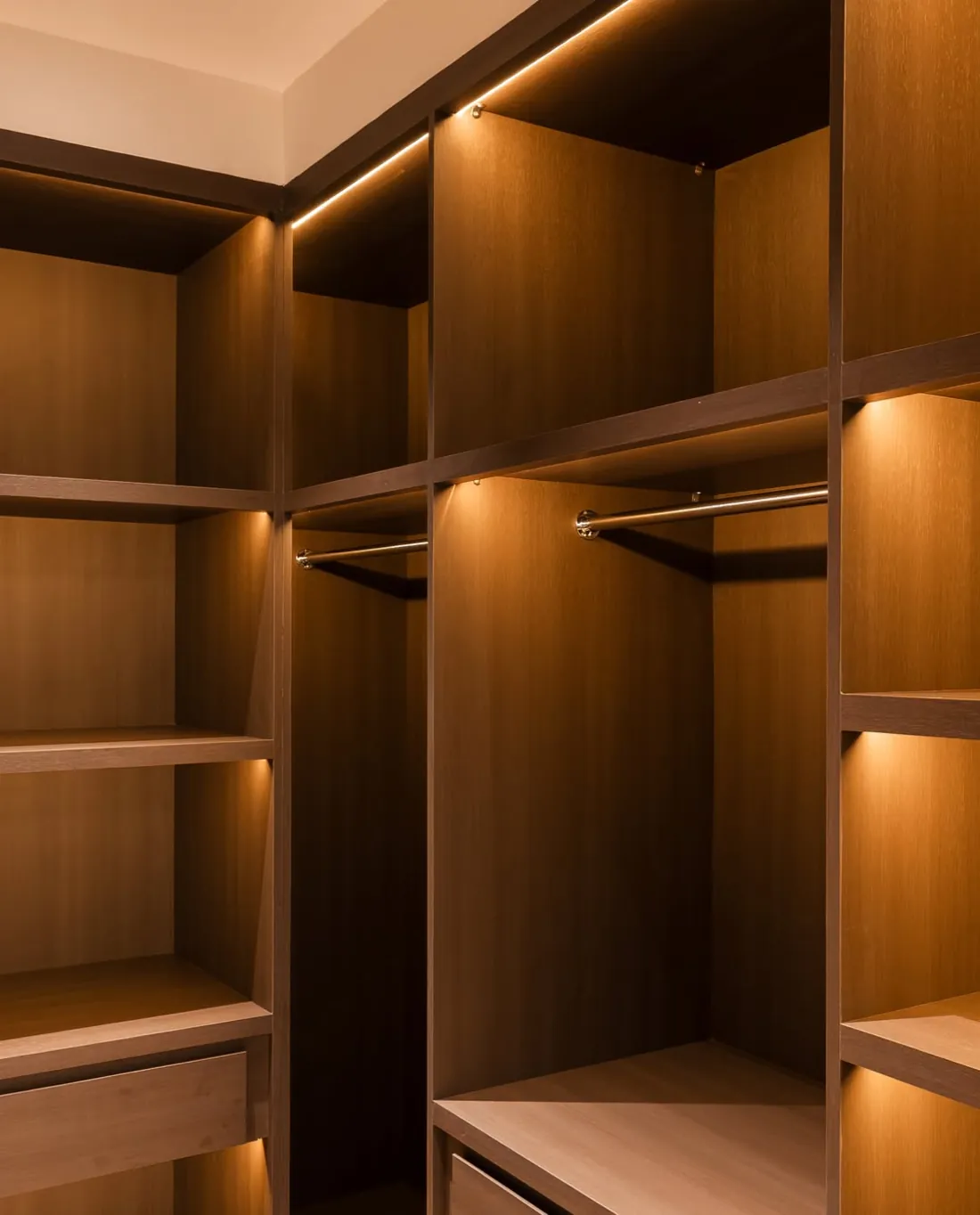 Walk in wardrobe in warm wood with integrated lighting